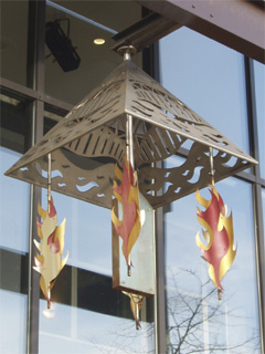 A metal pyramid with dangling flames hanging over the door to the Copthorne