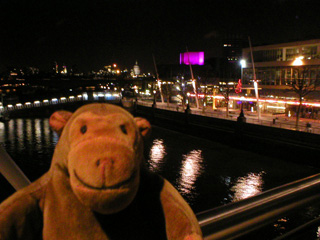 Mr Monkey looking at the Southbank and the river from the Hungerford Bridge