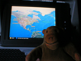 Mr Monkey looking at a map of the plane flying to Seattle