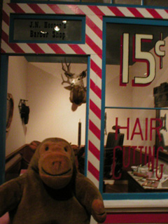 Mr Monkey outside a replica barber's shop