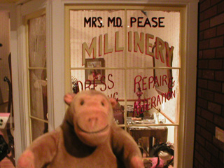 Mr Monkey outside a replica milliners