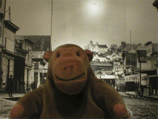 Mr Monkey looking at a large photo of a Seattle street