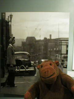 Mr Monkey looking at a picture of a woman war-worker walking homelooking at a picture of a woman war-worker walking home