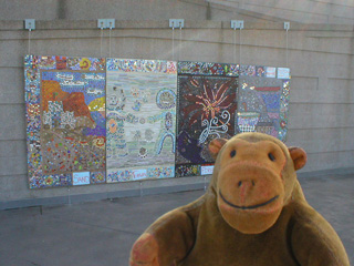 Mr Monkey looking at a glass mosaic outside the museum