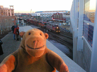 Mr Monkey watching a freight train on the railroad along the Seattle waterfront