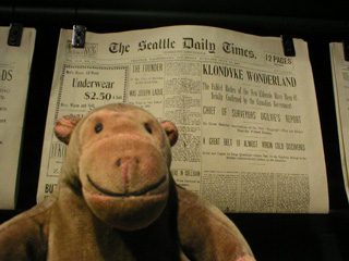Mr Monkey reading a Seattle newpaper about the discovery of gold in the Klondike