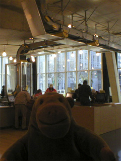 Mr Monkey looking at the book return conveyor system