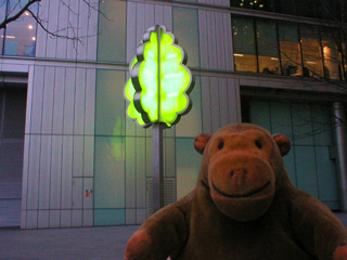 Mr Monkey looking at an illuminated metal tree beside the Thames