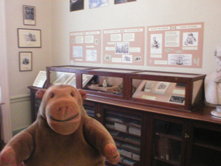Mr Monkey looking at a display about how Dickens wrote