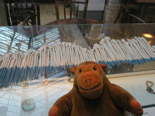 Mr Monkey looking at a row of blue and white clay shapes