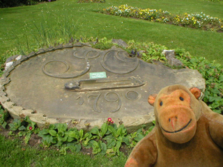Mr Monkey looking at the date stone of the mill