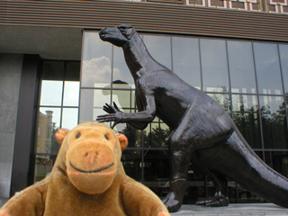 Mr Monkey looking at the wooden iguanodon