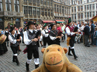 Mr Monkey watching a band of Belgian bagpipers