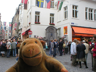 Mr Monkey looking at the Mannekin Pis dressed as a hockey player