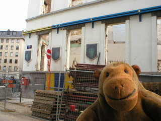 Mr Monkey looking at a half demolished building