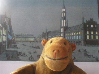 Mr Monkey with an illuminated picture of the Grand Place