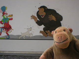 Mr Monkey looking at a mural showing Snowy scaring a gorilla