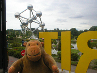 Mr Monkey looking at the Atomium from behind the Spirit of Europe sign