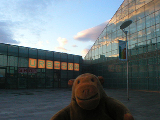 Mr Monkey looking at clouds reflected on the side of Urbis
