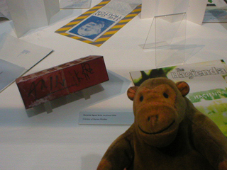 Mr Monkey looking at an autographed brick from the Hacienda