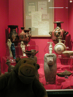 Mr Monkey looking at a case of antiquities