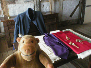 Mr Monkey looking at cloth samples on the table