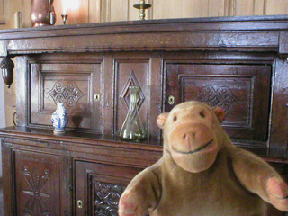 Mr Monkey looking at the dresser in the 17th century parlour