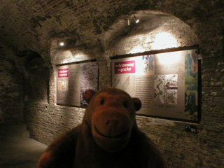 Mr Monkey looking at display panels about the history of fortification