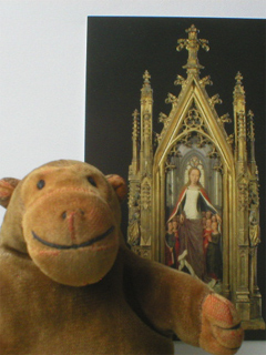 Mr Monkey with a postcard of the end of the St Ursula shrine