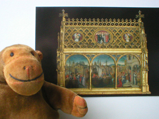 Mr Monkey with a postcard of the side of the St Ursula shrine
