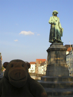 Mr Monkey looking at the statue of Jan Van Eyck