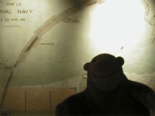 Mr Monkey looking at a wallmap of the Zeebrugge  raid