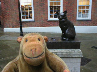 Mr Monkey looking at the statue of Johnson's cat in Gough Square