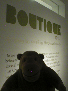 Mr Monkey looking at the panel explaining the Boutique exhibition