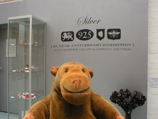 Mr Monkey looking at the sign for the Silver exhibition