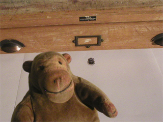 Mr Monkey looking into one of the drawers of the chest