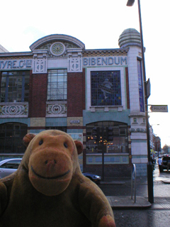 Mr Monkey looking at stained glass showing Bibendum waving his foot around