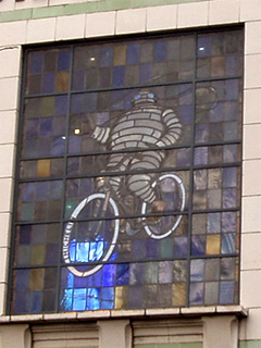Stained glass showing the Michelin Man riding a bicycle