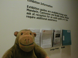 Mr Monkey looking at the exhibition handouts