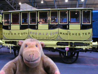 Mr Monkey looking at a replica Liverpool and Manchester passenger carriage