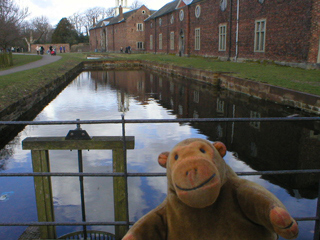 Mr Monkey looking at the sluice from the moat to the mill