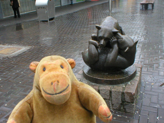 Mr Monkey looking at a statue of wrestling bears