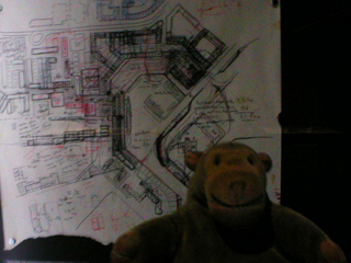 Mr Monkey looking at architects sketches of the layout of Almere
