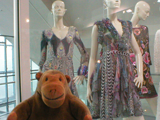 Mr Monkey looking at a case of summer print dresses