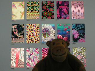 Mr Monkey looking at collection of examples of the prints used by Matthew Williamson