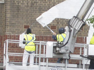 Workers painting on the side of the Tate modern
