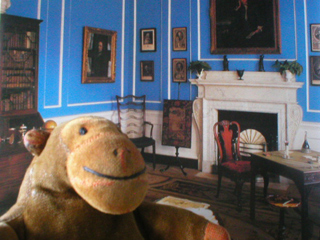 Mr Monkey in front of a photo of the study