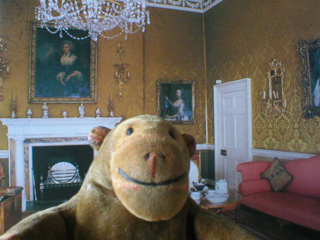 Mr Monkey in front of a photo of the drawing room