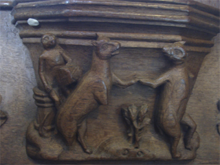 A misericord carving showing a monkey drumming for a pair of dancing animals