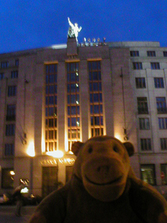 Mr Monkey looking at the Czech National Bank at night